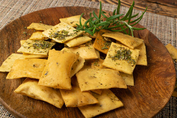 Pita Chips Pile on Wood Plate, Small Wheat Tortillas, Crunchy Flat Bread, Spicy Mediterranean Wheat Snack