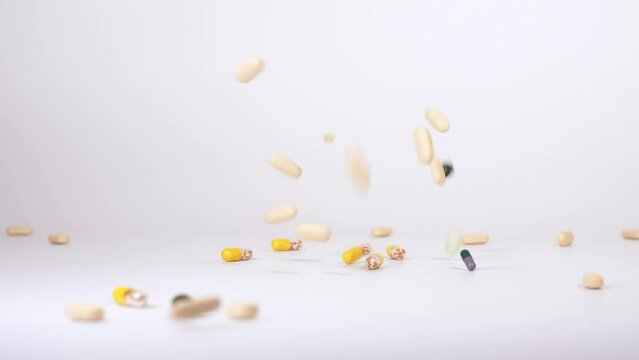 Colourful pharmaceutical products, tablets, pills and capsules falling down against white background. Concept of healthcare, medicine, pharmacy and drugs. Treatment and prevention of diseases. 4K