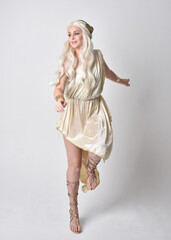 Full length portrait of beautiful blonde woman wearing a fantasy goddess toga costume with  magical...