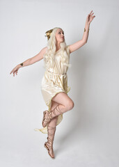 Full length portrait of beautiful blonde woman wearing a fantasy goddess toga costume with  magical...