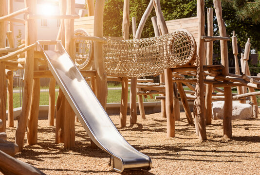 Children Playground  on Public Yard in Park with Swings, Slides and Climbing Equipment. Modern Wooden Playground Equipment of Entertainment Park for Kids.