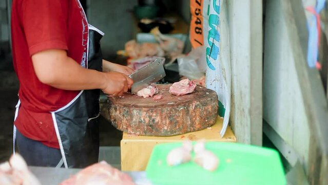 The process of the boiler or chicken being cut by traditional seller with simple tools and without hand protection
