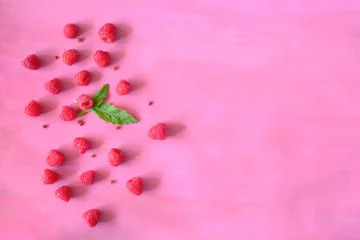 Selbstklebende Fototapeten fresh raspberry and green leaf on colored background, negative space technique, free copy space © Kirsten Hinte