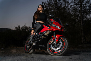 Obraz na płótnie Canvas Mujer en moto al atardecer