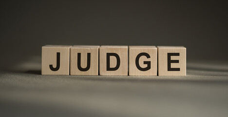 Judge - word from wooden blocks with letters, Judge, try, referee, adjudicate concept, black...