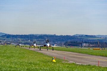 Fototapeta premium Fighters Northrop F-5E Tiger II of air display team Patrouille Swiss of Swiss Air Force taxiing to runway on a sunny spring day. Photo taken March 22nd, 2023, Emmen, Switzerland.