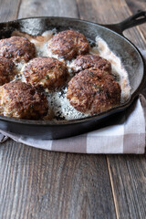 Danish Frikadeller or pork meatballs in a cast iron pan