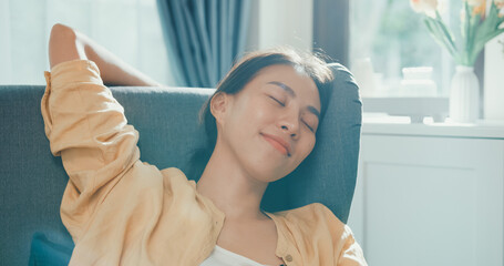 Close-up Youth asia female girl or university student sit on sofa chair take a rest relax feel chill and calm after finish work in living room at house. Environment at home, Work life balance concept. © tirachard