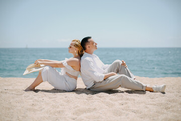 Lovers siting looking into sky and ocean, mountion, under sun.  Vacation, tourism, hooneymoon. Girl with a long hair.