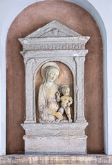 Copenhagen, Denmark - September 13, 2010: Madonna relief closeup at Sankt Angars kirke, Catholic Church. White frame on brown background with Jesus bacy and Mary mother slightly colored