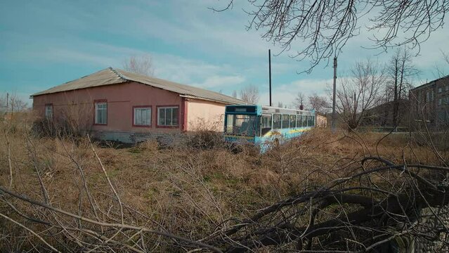 House secluded and left for a better life elsewhere after soviet collaps. Deserted building with along with bus wreck. Poverty concept.