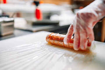 professional chef's hands making sushi roll in a restaurant kitchen