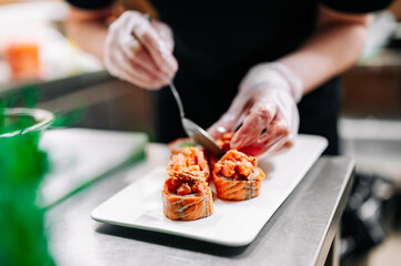 professional chef's hands making sushi roll in a restaurant kitchen