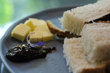 A homemade fresh bread, jam and butter on blue ceramic plate