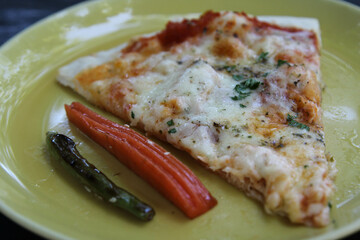 A piece of cheese pizza ready to eat on yellow plate