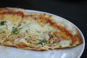Homemade cheese pizza ready to eat on white plate