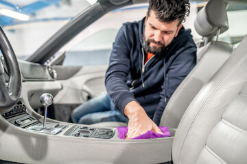 manual detailing and polishing of luxury car interiors with a microfiber