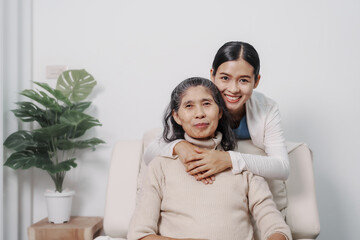 Hugging, love, valentine, care, Elderly mother with young daughter asia people only woman sitting on sofa at home have fun enjoying weekend together.