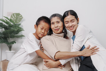 Fototapeta premium My grandmother and daughter and grandson hugged lovingly while sitting on the sofa with care and warmth, love, valentine, family, care.