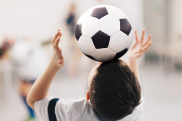 Soccer freestyle training class for school kids. Young boy keeping a soccer ball on his forehead. Youth footballer practicing soccer freestyle © matimix