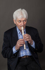 Portrait of an elderly musician with a pipe on a dark background. 