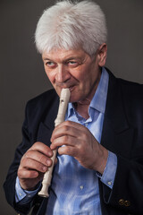 Portrait of an elderly musician with a pipe on a dark background. 