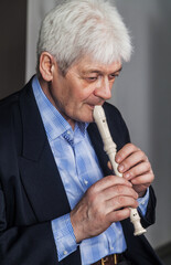 Portrait of an elderly musician with a pipe on a dark background. 