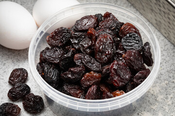 Plastic bowl with black flame raisins from Chili close up for baking 