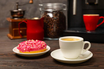 Fragrant delicious espresso coffee with pink strawberry donut, coffee machine on brown texture table. Good morning concept. Morning coffee. Sweet table. Colorful berry buns.Top view.
