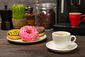 Obraz na płótnie Canvas Fragrant delicious espresso coffee with pink strawberry donut, coffee machine on brown texture table. Good morning concept. Morning coffee. Sweet table. Colorful berry buns.Top view.