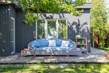 a large wicker sofa in fabric upholstery on a summer veranda outdoors in the sun against the...