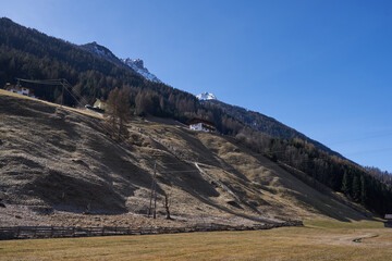 Fototapeta premium Neustift im Stubaital, Austria - March 16, 2023 - beautiful meadows and hillsides near Neustift at the end of the winter season 