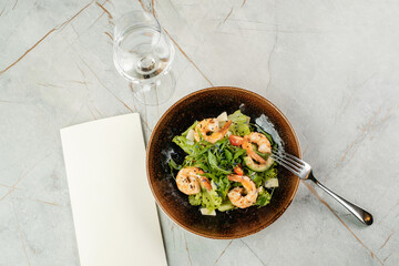 Salad with shrimps and herbs. Seafood dish in cafe.