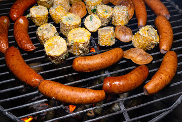 Baking sausages, sheeps cheese and corn on a metal grate fired with birch wood.
