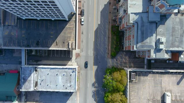 overhead aerial footage of the Bibb County Courthouse, the Fickling and Company building and other office buildings with cars on the street and lush green trees in Macon Georgia USA
