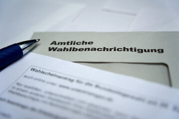 Obraz premium Official election notification (Wahlbenachrichtigung Bundestagswahl) for the federal election in germany. Tip of a ballpoint pen. High angle view. Closeup.