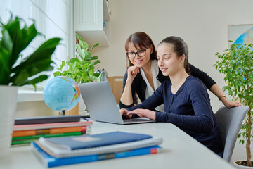 Teenage girl studying, female teacher with textbook helps tells teaches