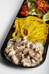 Grilled Chicken with Creamy Mushroom Sauce Linguine Pasta on Black Plate White Background