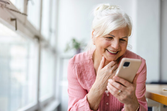 Smiling senior woman using smartphone 
