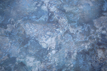 Blue background of decorative plaster with abstract spots. Unusual texture of this wall with beautiful patterns, creative surface background. Finishing coating for building cladding.