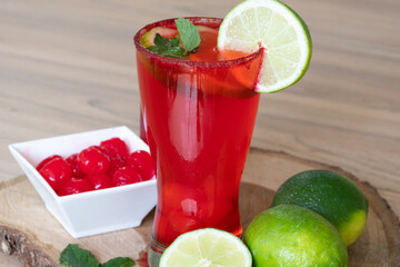 Cherry lemonade in crystal glass on brown wooden log