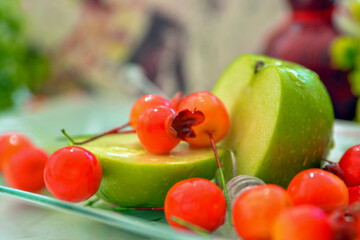 shana tovah!  A green apple decorated with small pomegranates with drops of honey on top of a decoration in honor of the Jewish New Year