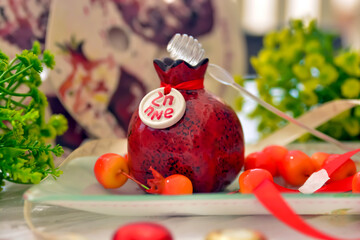 shana tovah!  A green apple decorated with small pomegranates with drops of honey on top of a...