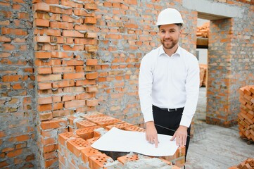 Construction concept of Engineer working at Construction Site with blue print.