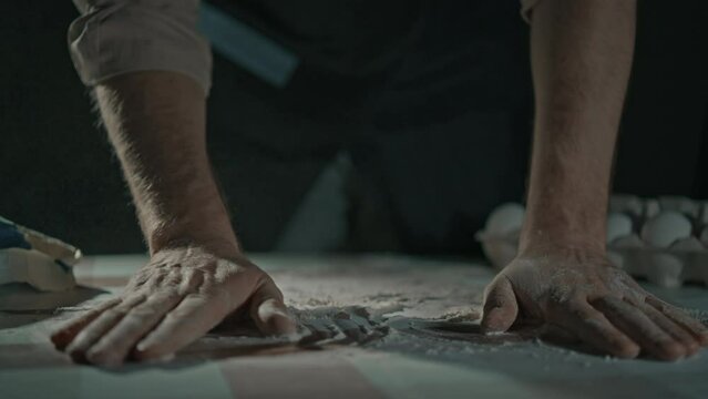 man preparing preparing surface for work flour on hand and table baking bread slow motion