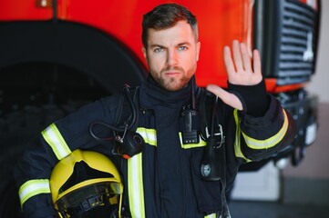 Obraz premium Photo of fireman with gas mask and helmet near fire engine