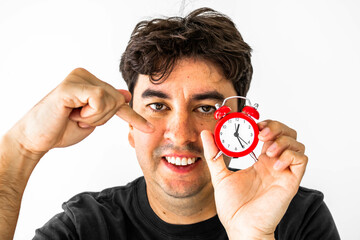 Smiling man holding a red clock with one hand and pointing with the other. Mention the satisfaction...