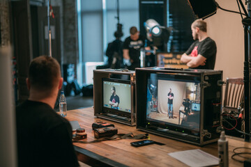 Film set, monitors and modern shooting equipment. Film crew, lighting devices, monitors, playbacks - filming equipment and a team