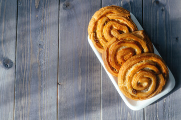 Buns on a wooden background. Break during the day to chat with friends and family over coffee and cake.
