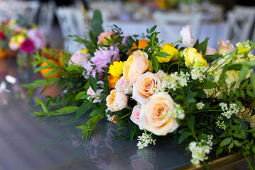 A table setting for a wedding reception with many fresh colourful flowers.